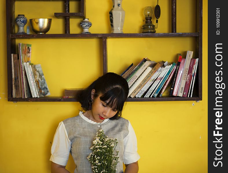 Woman Standing Beside Brown Wooden Shelf