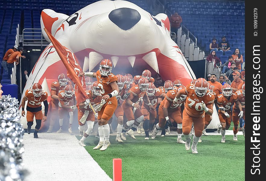 Football Team Running Thru Football Field