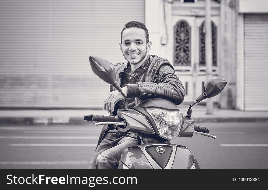 Grayscale Photography of Man Sitting on Motorcycle