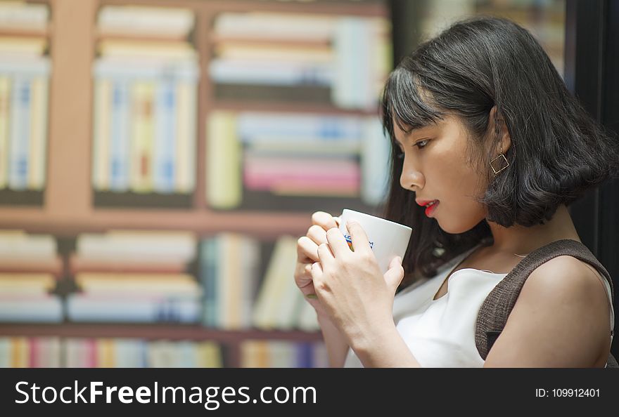 Photography of A Woman Holding White Coffee Mug