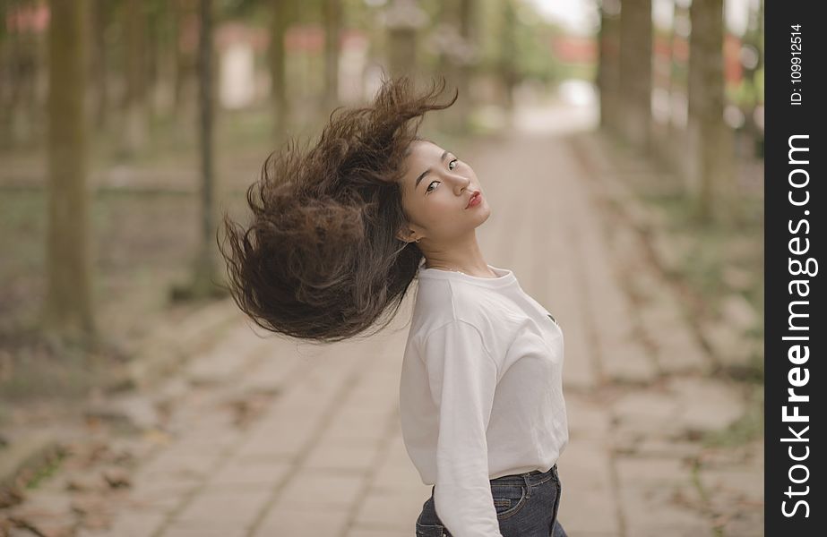 Closeup Photo Of Woman In White Crew-neck Long-sleeved Shirt Shaking Her Hair In The Middle On Road