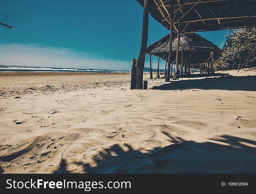 Brown Nipa Cottage Near Ocean At Daytime