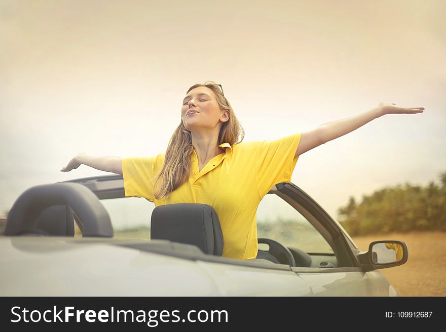 Woman Sitting on Car Under Gray Sky