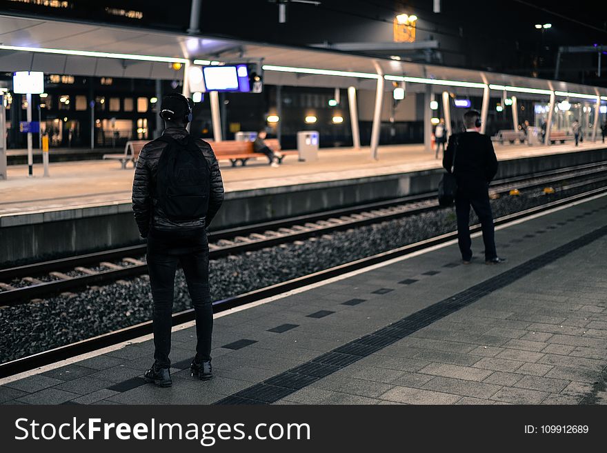 Photo of Two Men Standing Near Railway Station