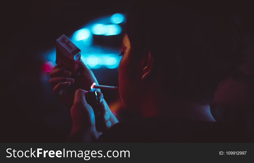 Man Lighting Up a Cigarette during Nighttime in Tilt Shift Lens Photograhy