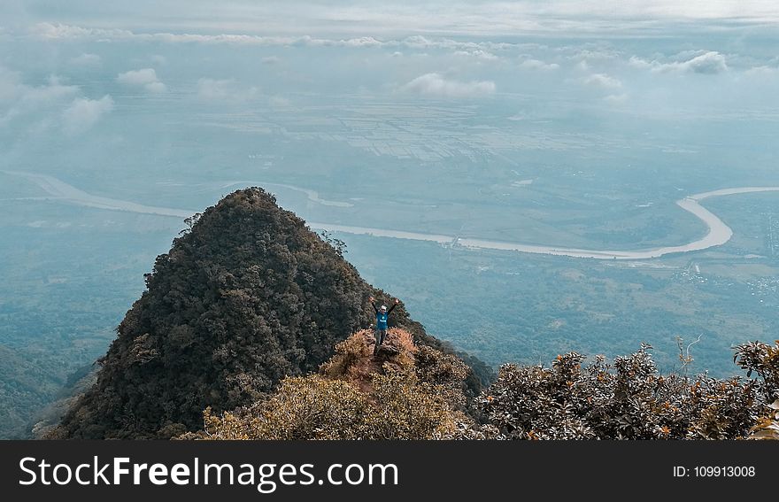 Man in Blue on Top of the Mountain With Areal View