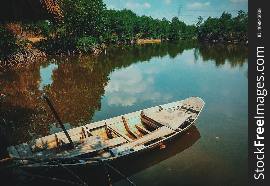 Brown Canoe Boat On Body Of Water