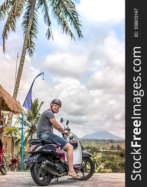 Man Riding Motor Scooter