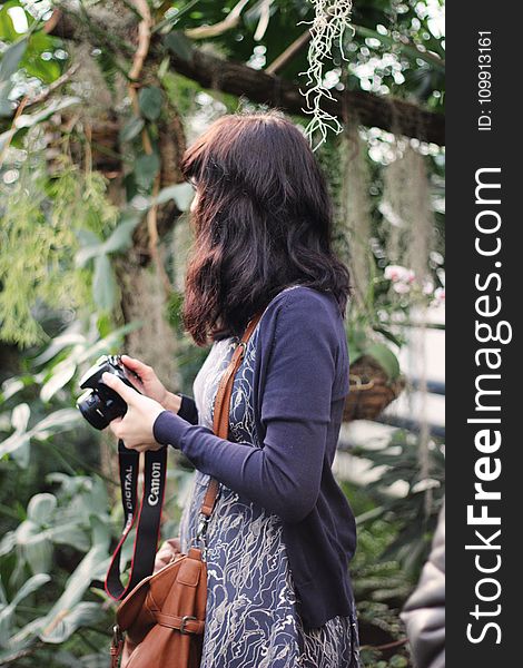 Woman in Blue Cardigan Holding Canon Dslr Camera