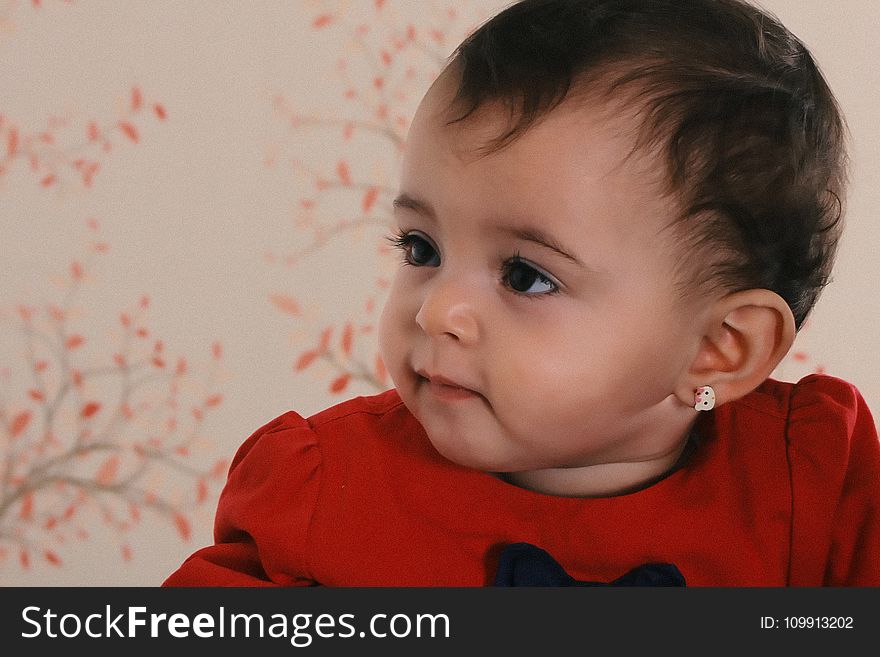 Baby Wearing Red Crew-neck Shirt Near Pink and Black Floral Surface