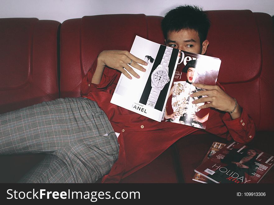 Photography Of A Man Holding Magazine