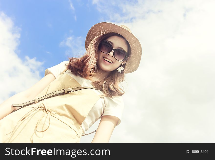 Woman Wearing Dress Smiling Taking for Picture Under Cloudy Skies