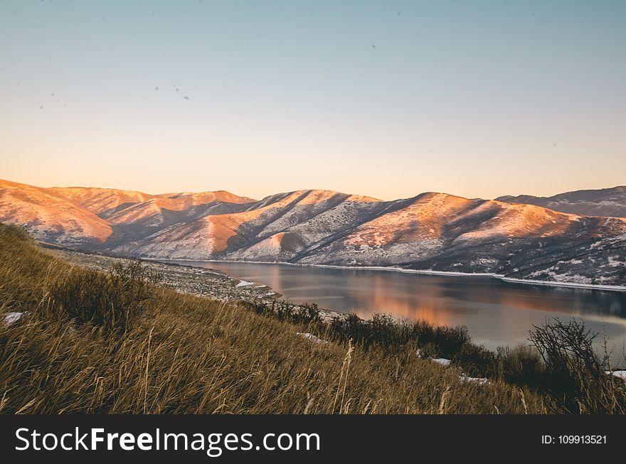 Mountains Near Lake Under Blue Sky