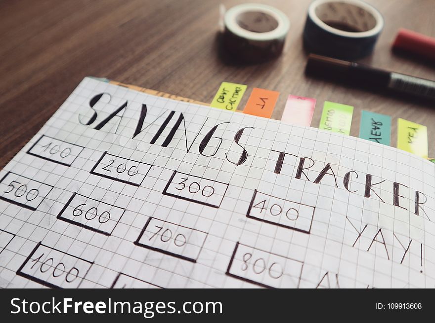 Savings Tracker on Brown Wooden Surface