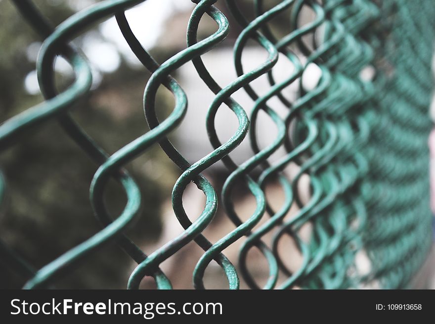 Selective Focus Photography of a Green Link Fence