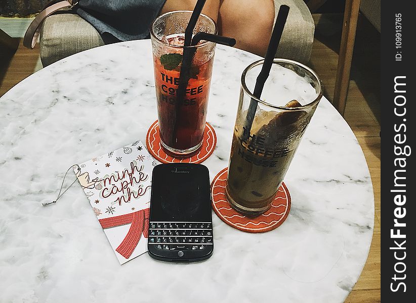 Photo Of Blackberry Phone Beside Two Tall Glasses