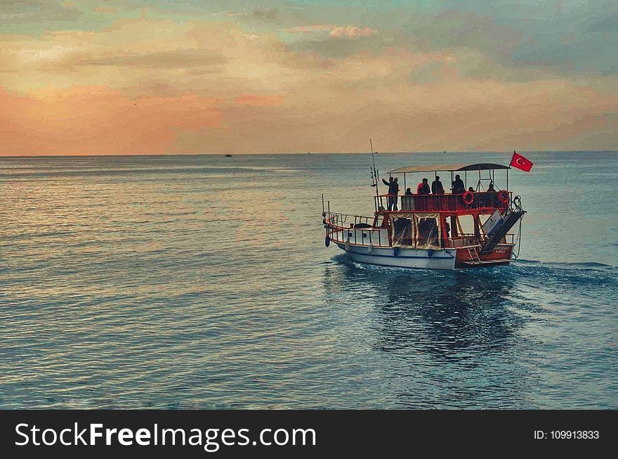 Brown and White Boat in the Middle of Ocean at Daytime