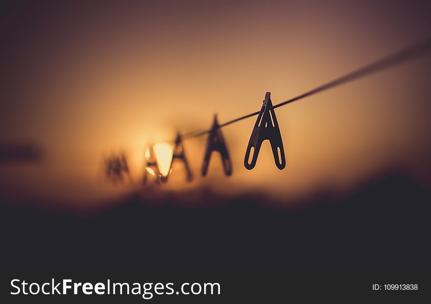 Shallow Focus Photography of Wooden Clothes Clip on Clothes String Rack