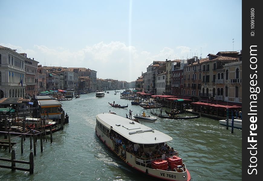 Gray Buildings Near Body of Water With Boats at Daytime