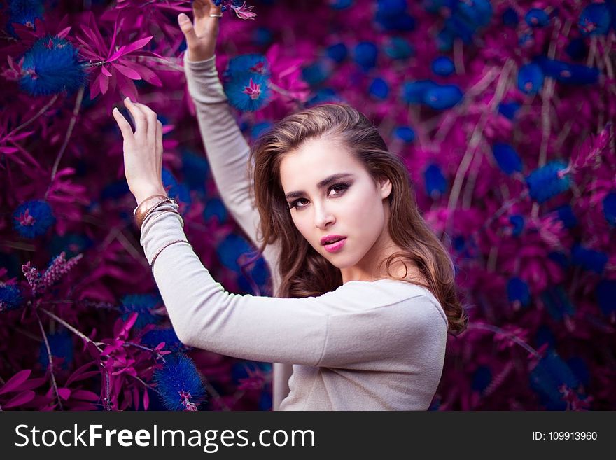 Woman Holding Purple and Blue Flowers