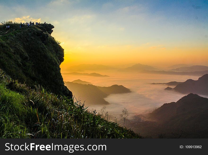 Landscape Photography of Cliff With Sea of Clouds during Golden Hour