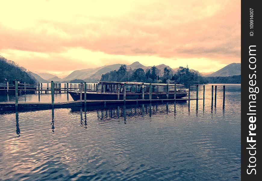 Boat Beside Dock during Golden Hour