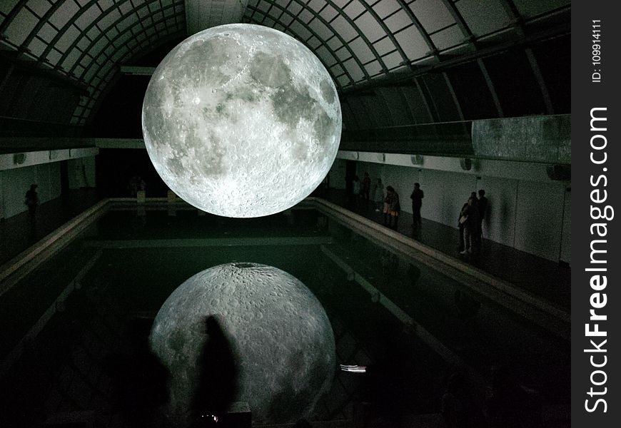 Photo of Moon Hologram Floating on Water Near People Inside Room