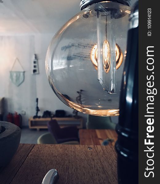 Clear Glass Lamp Near Brown Wooden Surface