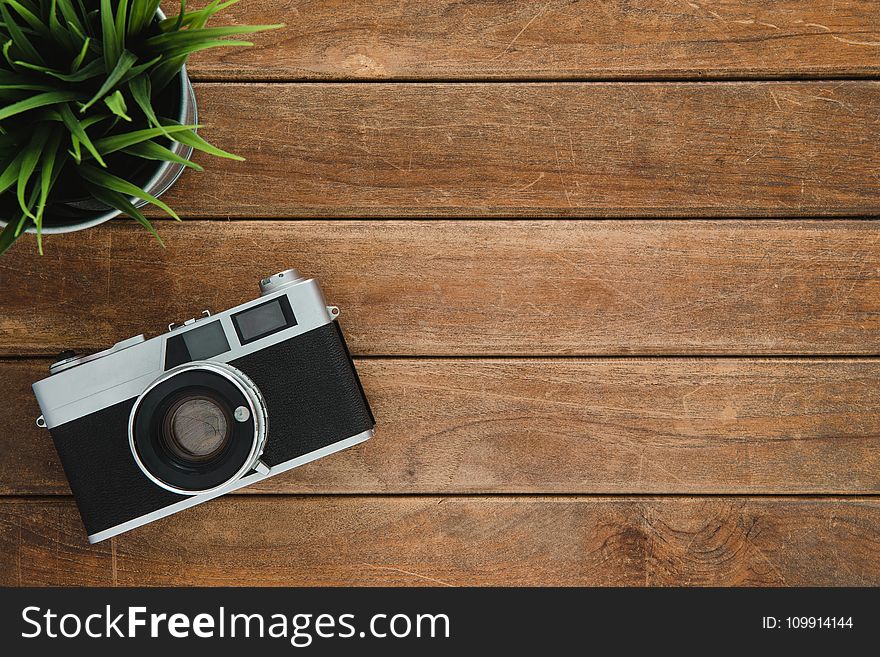 Black and Silver Film Camera on Brown Wooden Surface