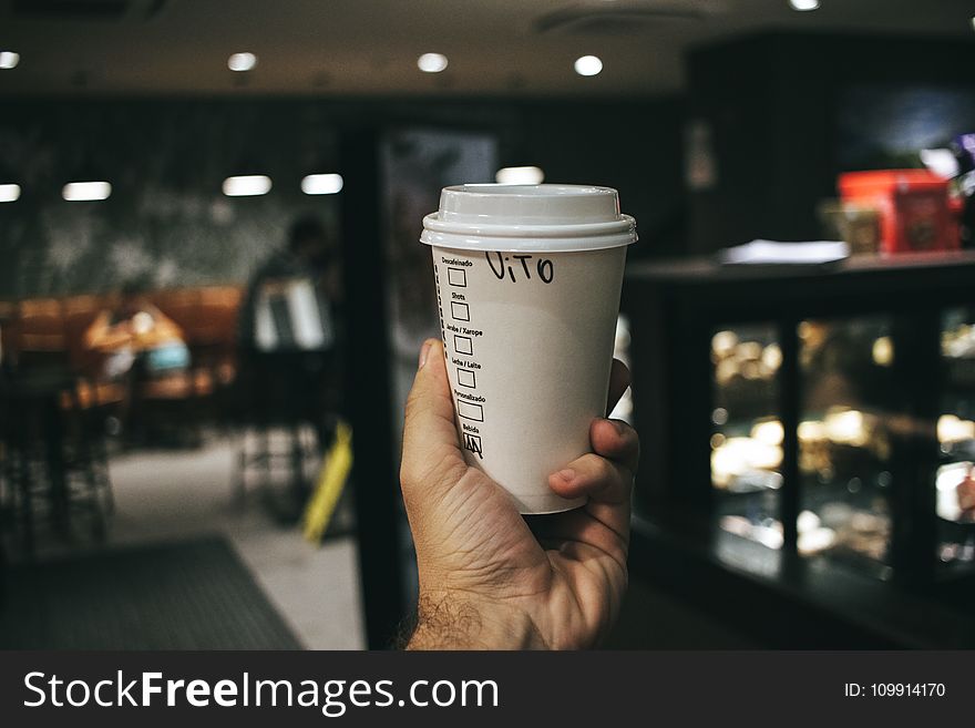 Person Holding Labeled Disposable Cup