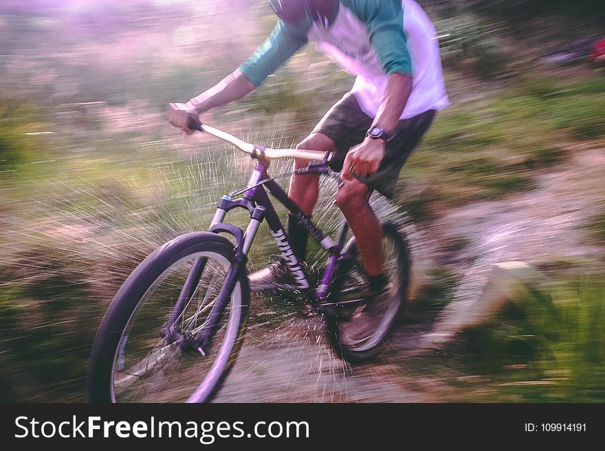 Man Riding Black and White Hardtail Mountain Bike