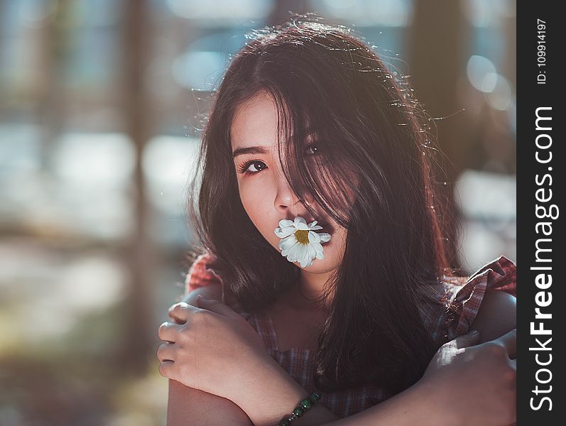 Close-up Photo Of Woman In Brown Sleeveless Top With White Daisy Flower