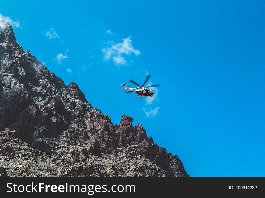 Photography Of White And Red Helicopter Flying