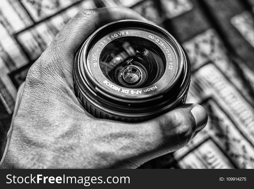 Grayscale Photography of Person Holding Dslr Zoom Lens