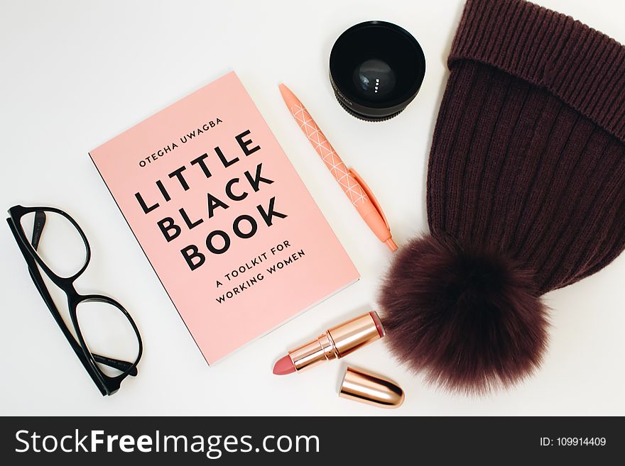 Little Black Book Beside Eyeglasses And Lipstick Case