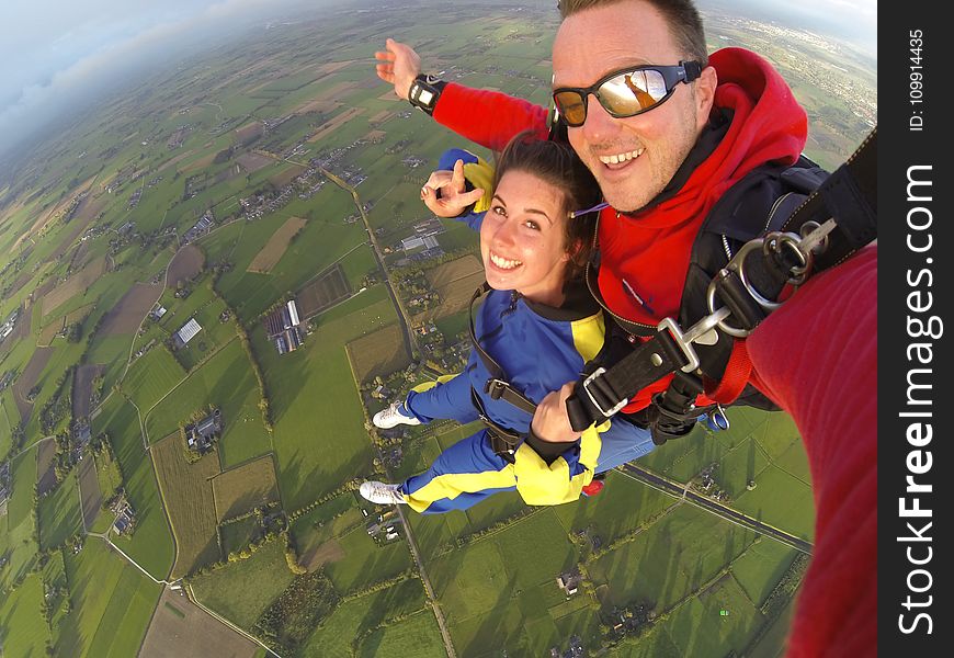 Woman And Man Wearing Overalls Sky Diving