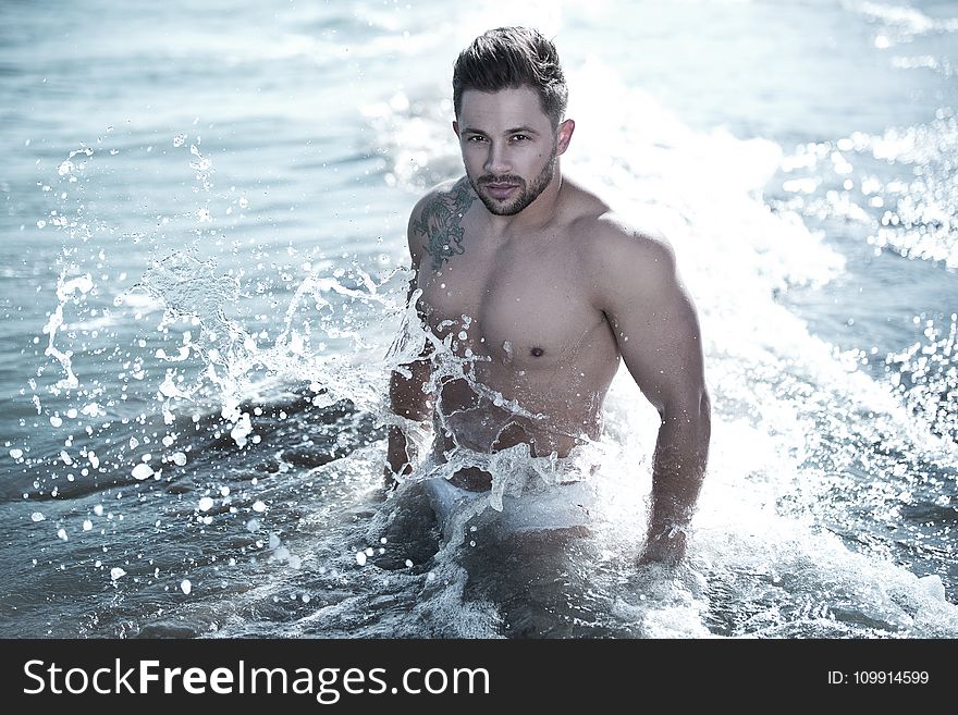 Photo of Man in Body of Water Wearing White Brief