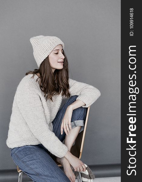 Woman in White Sweater and Beanie With Blue Denim Pants
