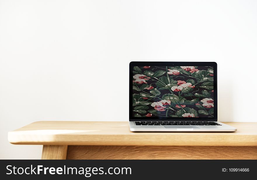 Macbook Pro on Top of Brown Desk