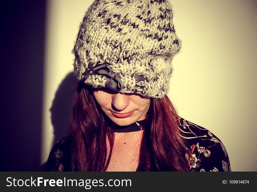 Woman Wearing Black and Gray Knit Cap in the White Wall Paint Room