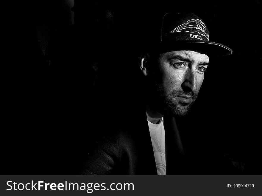 Grayscale Photo Portrait of Man in Black Cap