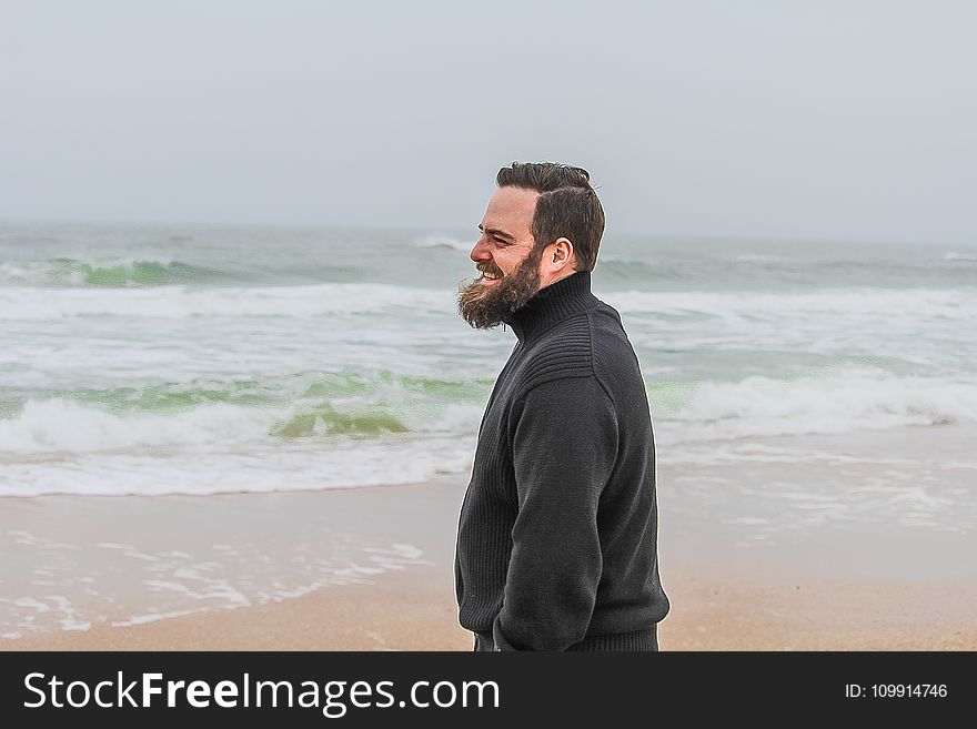 Man in Black Turtle-neck Jacket Standing on Shore