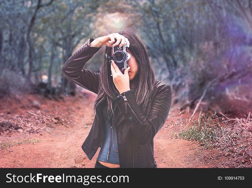 Woman Wearing Black Leather Jacket Holding Camera