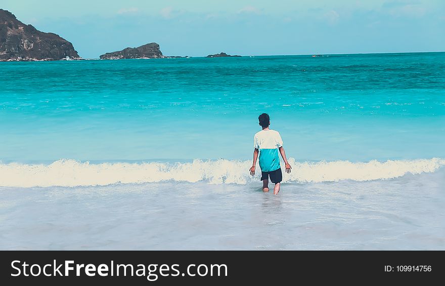 Photo of Man Walking by the Seashore