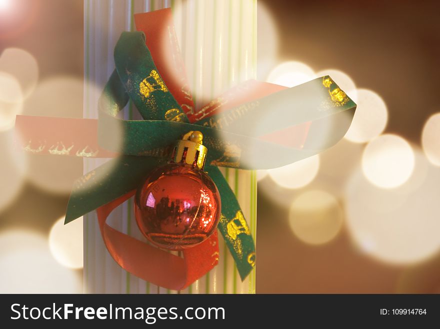 Photography Of Red Bauble With Green Ribbon