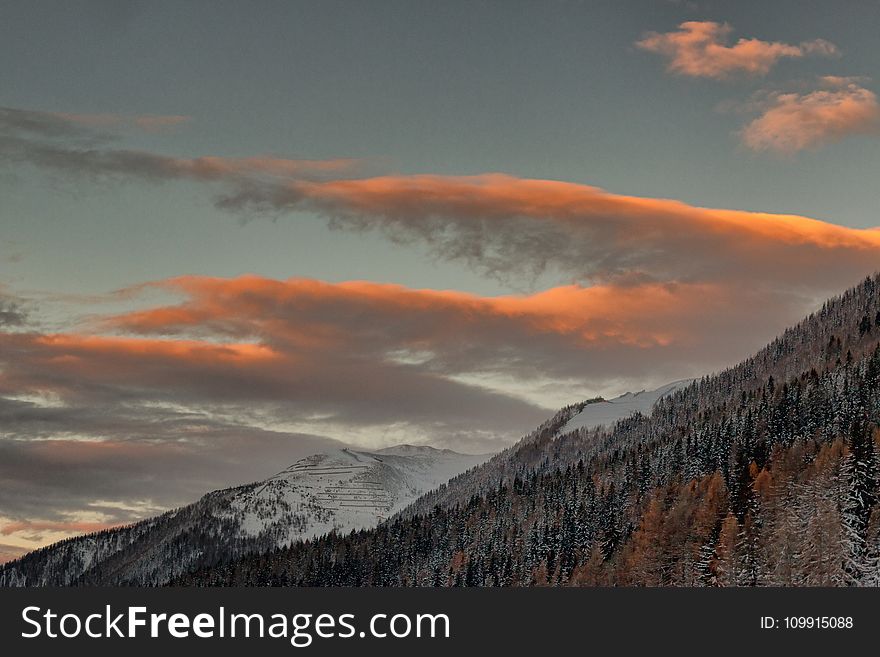 A View Of Snowy Mountains Under Cloudy Sky