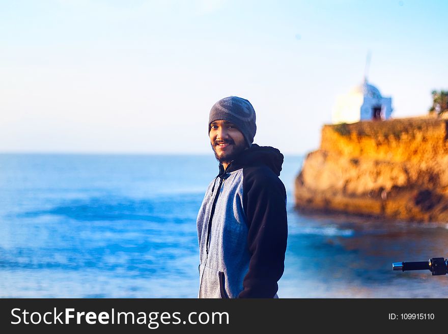 Man Wearing Gray Knit Cap and Pullover Hoodie Beside Beach
