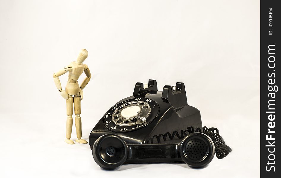 Black Rotary Telephone Beside Beige Manekin