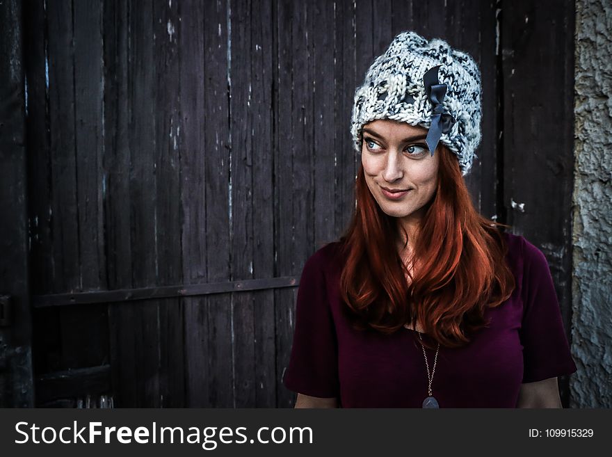 Woman Wearing Maroon Short-sleeved Shirt and White and Grey Knit Cap