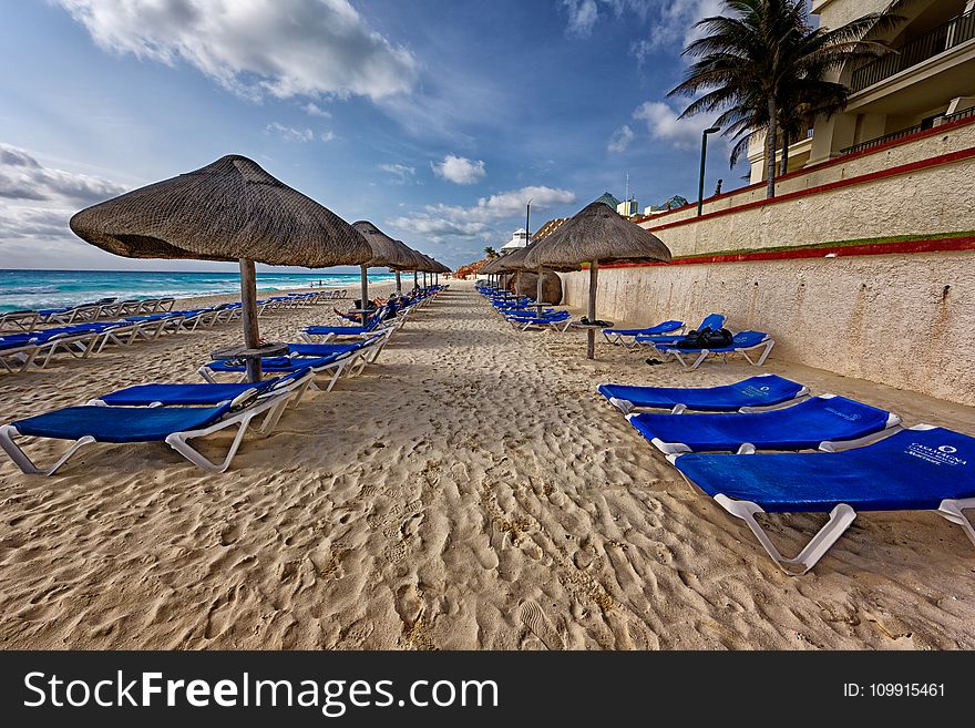 Blue And White Outdoor Chaise Lounges And Nipa Hut Beside Seashore